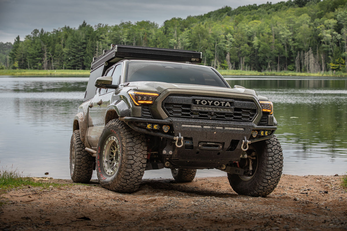 4th Gen Toyota Tacoma on Lock Off-Road Combat wheels by a lake, front three-quarter view