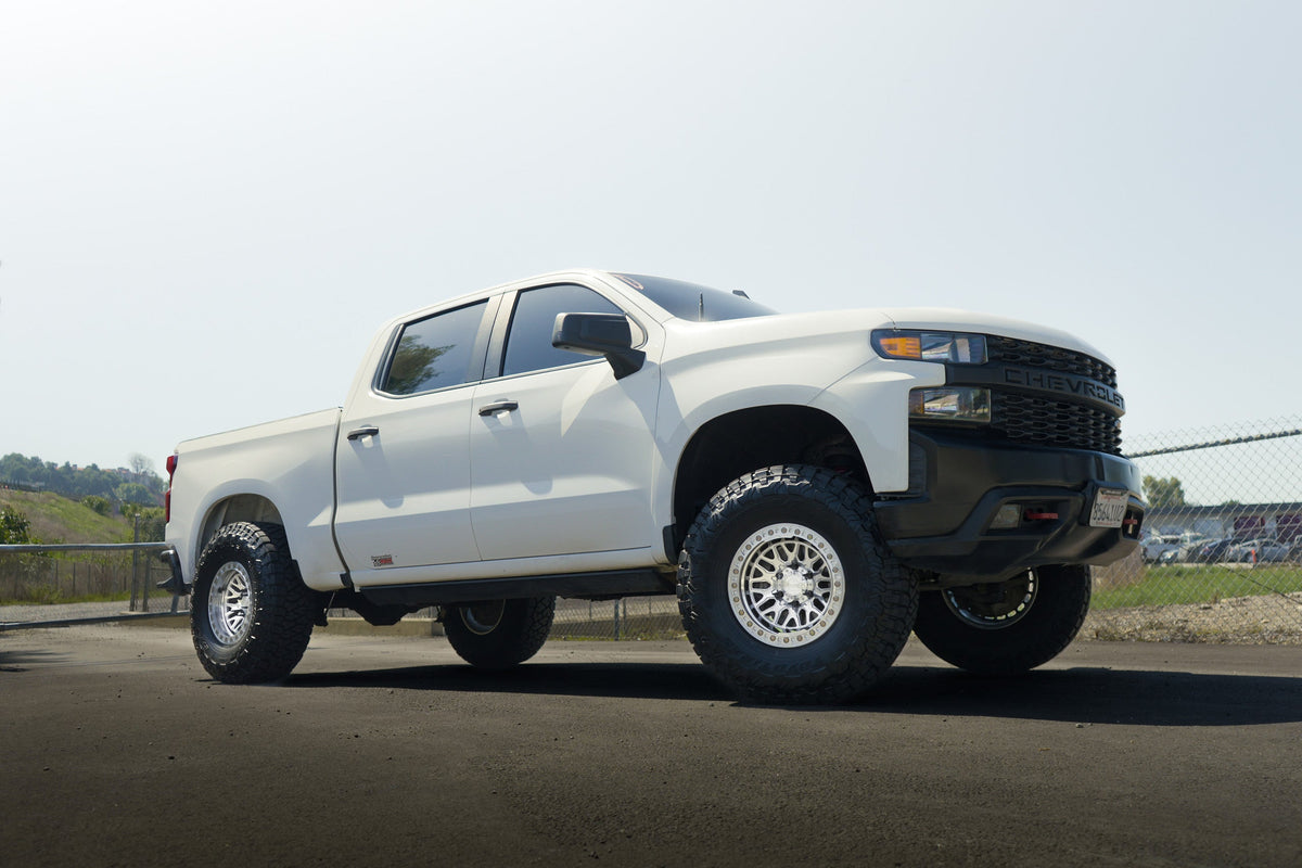 White Chevy Silverado on Lock Off-Road Invader beadlock wheels, front three-quarter view
